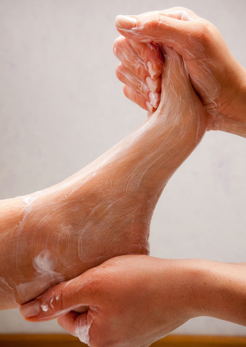 Nail technician performs foot massage.